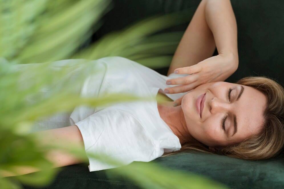 Relaxujici žena ležící v bílém tričku v příjemném prostředí přírody